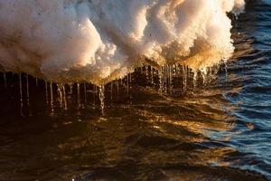 costa del mar báltico con guijarros y hielo al atardecer foto