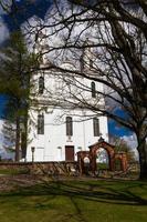 A White Catholic Church on a Summer Day With Dark Clouds in the Background photo