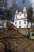 A White Catholic Church on a Summer Day With Dark Clouds in the Background photo