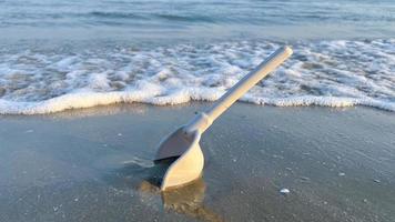 un juguete de playa excavado en la arena de la playa foto