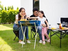 familias padre madre hijo chica hembra macho mujer hombre grupo feliz al aire libre barbacoa barbacoa comer picnic vacación comida comida cerdo sabrosos junto vacaciones huerto verde natural sonrisa chistoso fiestas foto