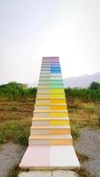 Rainbow or colorful stairs way or step at park with grass field, green tree and sky background. Vintage structure and Retro object. Art structure and built. Growth up, Sucess and Top up concept photo