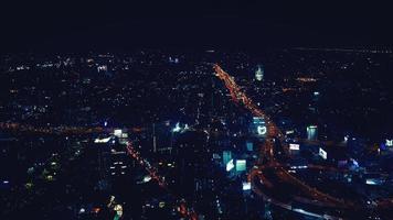 Aerial view of Bangkok city, Thailand at night. Landscape view of town with colorful light, street or road, transportation and highway in blue vintage tone. Beautiful life in Asian country concept