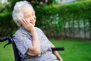 anciana asiática discapacitada paciente sentada en silla de ruedas eléctrica en el parque, concepto médico.