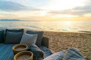 pillows on outdoor patio deck chair on beach with sunset times photo