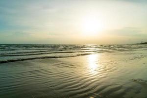 hermosa playa de mar con puesta de sol foto