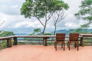 barra de madera y silla con fondo de montaña foto