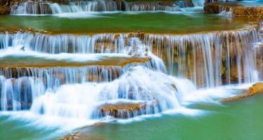 increíble cascada colorida en el bosque del parque nacional durante la primavera, hermoso bosque profundo en tailandia, larga exposición técnica, durante las vacaciones y el tiempo de relajación. foto