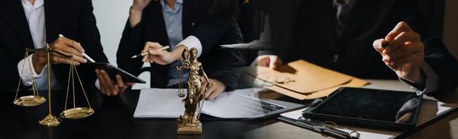 Business and lawyers discussing contract papers with brass scale on desk in office. Law, legal services, advice, justice and law concept picture with film grain effect photo