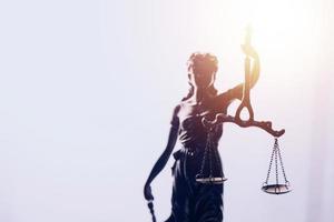 Justice and law concept.Male judge in a courtroom with the gavel, working with, computer and docking keyboard, eyeglasses, on table in morning light photo