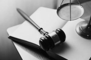 Justice and law concept.Male judge in a courtroom with the gavel, working with, computer and docking keyboard, eyeglasses, on table in morning light photo