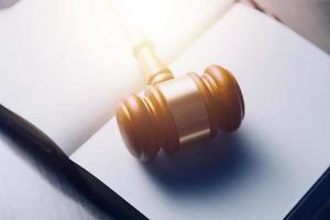 Justice and law concept.Male judge in a courtroom with the gavel, working with, computer and docking keyboard, eyeglasses, on table in morning light photo