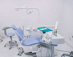 Stomatology concept, partial portrait of girl with strong white teeth looking at camera and smiling, fingers near face. Closeup of young woman at dentist's, studio, indoors photo