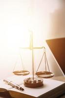 Justice and law concept.Male judge in a courtroom with the gavel, working with, computer and docking keyboard, eyeglasses, on table in morning light photo