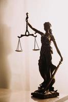 Justice and law concept.Male judge in a courtroom with the gavel, working with, computer and docking keyboard, eyeglasses, on table in morning light photo