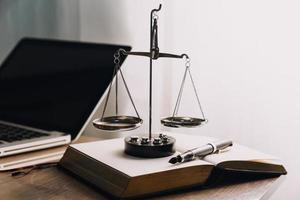 Justice and law concept.Male judge in a courtroom with the gavel, working with, computer and docking keyboard, eyeglasses, on table in morning light photo