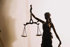 Justice and law concept.Male judge in a courtroom with the gavel, working with, computer and docking keyboard, eyeglasses, on table in morning light photo