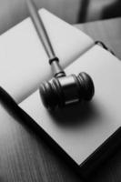 Justice and law concept.Male judge in a courtroom with the gavel, working with, computer and docking keyboard, eyeglasses, on table in morning light photo