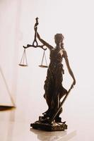 Justice and law concept.Male judge in a courtroom with the gavel, working with, computer and docking keyboard, eyeglasses, on table in morning light photo