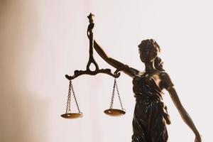 Justice and law concept.Male judge in a courtroom with the gavel, working with, computer and docking keyboard, eyeglasses, on table in morning light photo