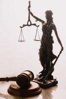 Justice and law concept.Male judge in a courtroom with the gavel, working with, computer and docking keyboard, eyeglasses, on table in morning light photo