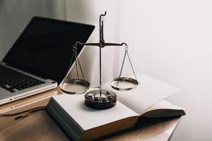 Justice and law concept.Male judge in a courtroom with the gavel, working with, computer and docking keyboard, eyeglasses, on table in morning light photo