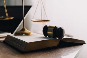 Justice and law concept.Male judge in a courtroom with the gavel, working with, computer and docking keyboard, eyeglasses, on table in morning light photo