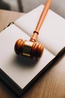 Justice and law concept.Male judge in a courtroom with the gavel, working with, computer and docking keyboard, eyeglasses, on table in morning light photo