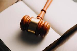 Justice and law concept.Male judge in a courtroom with the gavel, working with, computer and docking keyboard, eyeglasses, on table in morning light photo