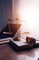 Justice and law concept.Male judge in a courtroom with the gavel, working with, computer and docking keyboard, eyeglasses, on table in morning light photo