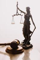 Justice and law concept.Male judge in a courtroom with the gavel, working with, computer and docking keyboard, eyeglasses, on table in morning light photo