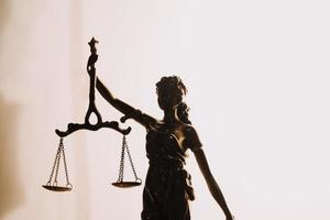 Justice and law concept.Male judge in a courtroom with the gavel, working with, computer and docking keyboard, eyeglasses, on table in morning light photo