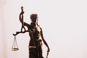 Justice and law concept.Male judge in a courtroom with the gavel, working with, computer and docking keyboard, eyeglasses, on table in morning light photo