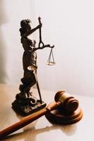 Justice and law concept.Male judge in a courtroom with the gavel, working with, computer and docking keyboard, eyeglasses, on table in morning light photo