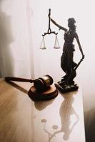 Justice and law concept.Male judge in a courtroom with the gavel, working with, computer and docking keyboard, eyeglasses, on table in morning light photo