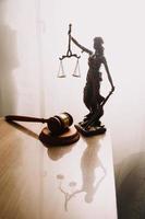 Justice and law concept.Male judge in a courtroom with the gavel, working with, computer and docking keyboard, eyeglasses, on table in morning light photo