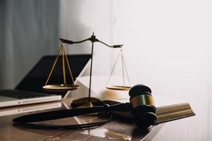 Justice and law concept.Male judge in a courtroom with the gavel, working with, computer and docking keyboard, eyeglasses, on table in morning light photo