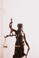 Justice and law concept.Male judge in a courtroom with the gavel, working with, computer and docking keyboard, eyeglasses, on table in morning light photo