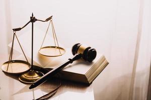 Justice and law concept.Male judge in a courtroom with the gavel, working with, computer and docking keyboard, eyeglasses, on table in morning light photo