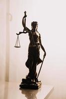 Justice and law concept.Male judge in a courtroom with the gavel, working with, computer and docking keyboard, eyeglasses, on table in morning light photo