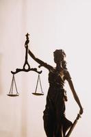 Justice and law concept.Male judge in a courtroom with the gavel, working with, computer and docking keyboard, eyeglasses, on table in morning light photo