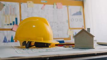 Two colleagues discussing data working and tablet, laptop with on on architectural project at construction site at desk in office photo