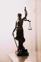 Justice and law concept.Male judge in a courtroom with the gavel, working with, computer and docking keyboard, eyeglasses, on table in morning light photo