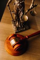 Justice and law concept.Male judge in a courtroom with the gavel, working with, computer and docking keyboard, eyeglasses, on table in morning light photo