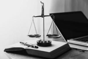 Justice and law concept.Male judge in a courtroom with the gavel, working with, computer and docking keyboard, eyeglasses, on table in morning light photo