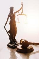 Justice and law concept.Male judge in a courtroom with the gavel, working with, computer and docking keyboard, eyeglasses, on table in morning light photo