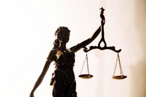 Justice and law concept.Male judge in a courtroom with the gavel, working with, computer and docking keyboard, eyeglasses, on table in morning light photo