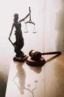 Justice and law concept.Male judge in a courtroom with the gavel, working with, computer and docking keyboard, eyeglasses, on table in morning light photo