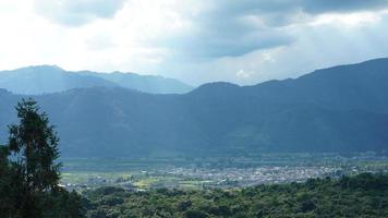 la cosecha de la vista del campo de arroz amarillo ubicada en el valle entre las montañas con el cielo nublado como fondo foto