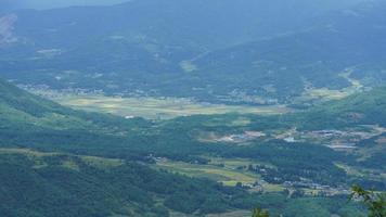 The harvesting yellow rice field view located in the valley among the mountains with the cloudy sky as background photo